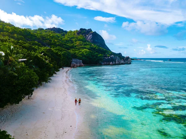 Anse Source dArgent beach, La Digue Island, Seyshelles, Drone aerial view of La Digue Seychelles bird eye view, couple men and woman walking at the beach during sunset at a luxury vacation — Foto de Stock