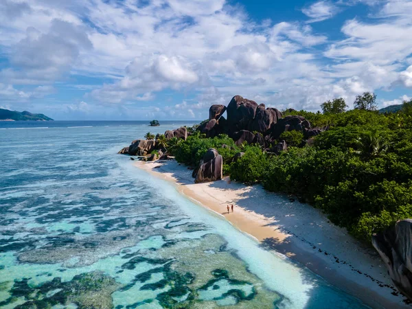 Anse Source dArgent beach, La Digue Island, Seyshelles, Drone aerial view of La Digue Seychelles bird eye view, couple men and woman walking at the beach during sunset at a luxury vacation — Zdjęcie stockowe