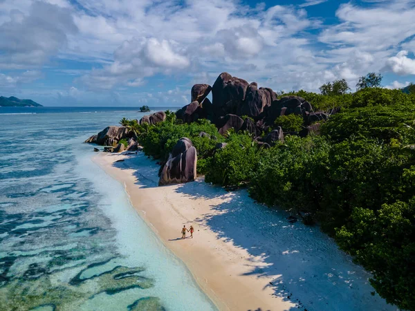 Anse Source dArgent beach, La Digue Island, Seyshelles, Drone vista aerea di La Digue Seychelles bird eye view, coppia di uomini e donne che camminano in spiaggia durante il tramonto in una vacanza di lusso — Foto Stock