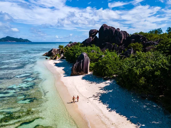 Anse Source dArgent beach, La Digue Island, Seyshelles, Drone aerial view of La Digue Seychelles bird eye view, couple men and woman walking at the beach during sunset at a luxury vacation — Zdjęcie stockowe