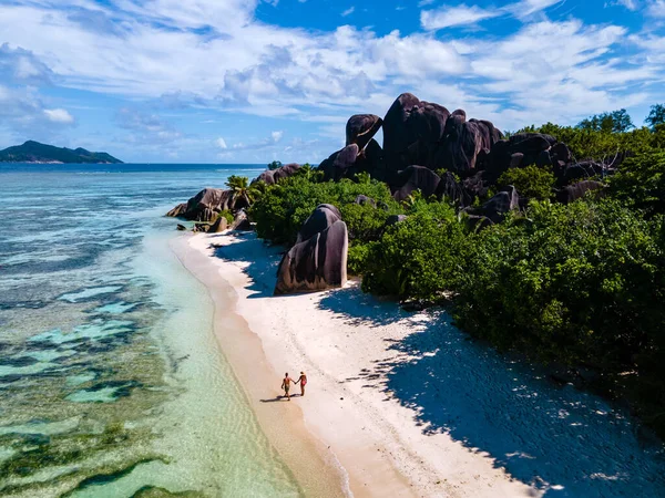 Anse Source Dargent beach, La Digue Island, Seyshelles, La Digueセイシェルのドローンの空の景色鳥の目の景色,豪華な休暇で日没時にビーチを歩くカップルの男性と女性 — ストック写真