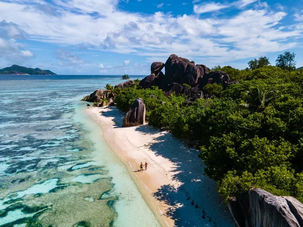 Anse Source dArgent beach, La Digue Island, Seyshelles, Drone vista aerea di La Digue Seychelles bird eye view, coppia di uomini e donne che camminano in spiaggia durante il tramonto in una vacanza di lusso — Foto Stock