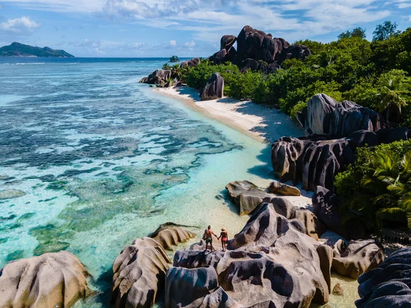 Anse Source dArgent beach, La Digue Island, Seyshelles, Drone aerial view of La Digue Seychelles bird eye view, couple men and woman walking at the beach during sunset at a luxury vacation — Zdjęcie stockowe