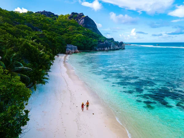 Anse Source dArgent beach, La Digue Island, Seyshelles, Drone aerial view of La Digue Seychelles bird eye view, couple men and woman walking at the beach during sunset at a luxury vacation — Stock fotografie