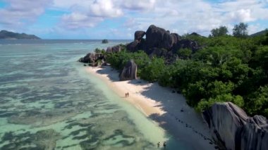 Anse Source dArgent beach, La Digue Island, Seyshelles, Drone aerial view of La Digue Seychelles bird eye view, couple men and woman walking at the beach during sunset at a luxury vacation