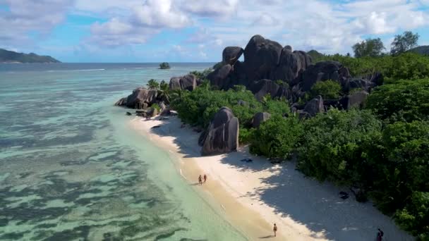 Anse Source dArgent beach, La Digue Island, Seyshelles, Drone aerial view of La Digue Seychelles bird eye view, couple men and woman walking at the beach during sunset at a luxury vacation — стокове відео