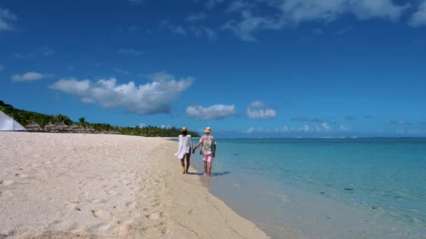 Le Morne strand Mauritius, Trópusi strand pálmafákkal és fehér homokkal kék óceán pár férfi és nő sétál a strandon nyaralás közben — Stock videók