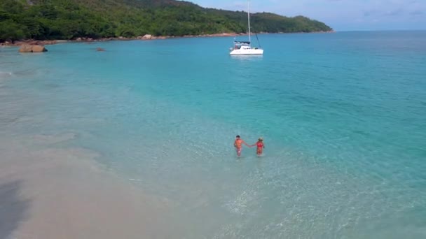 Praslin Seychelle-szigetek trópusi sziget withe strandok és pálmafák, pár férfi és nő középkorú nyaralás a Seychelle-szigeteken látogatás a trópusi strand Anse Lazio Praslin Seychelles drón kilátás — Stock videók