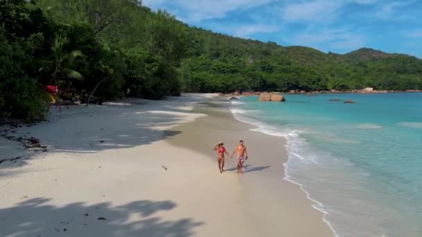 Praslin Seychelles tropical island with withe beaches and palm trees, couple men and women mid age on vacation at the Seychelles visiting the tropical beach of Anse Lazio Praslin Seychelles drone view — Stock video