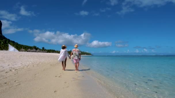 Le Morne beach Mauritius,Tropical beach with palm trees and white sand blue ocean couple men and woman walking at the beach during vacation — Stockvideo