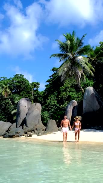 Anse Takamaka praia Mahe Seychelles, praia tropical com palmeiras e um oceano azul, casal homem e mulher na praia — Vídeo de Stock