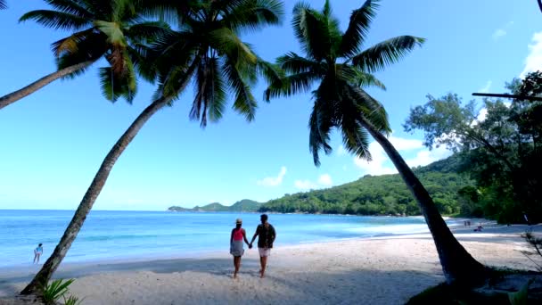 Anse Takamaka beach Mahe Seychelles, tropical beach with palm trees and a blue ocean, couple man and woman on the beach — Vídeo de Stock