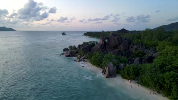 Anse Source dArgent beach, La Digue Island, Seyshelles, Drone légi kilátás a La Digue Seychelles madártávlatból, pár férfi és nő sétál a strandon napnyugtakor egy luxus nyaralás — Stock videók