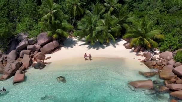 Praslin Seychelles isla tropical con playas y palmeras, pareja de hombres y mujeres de mediana edad de vacaciones en las Seychelles visitando la playa tropical de Anse Lazio Praslin Seychelles vista drone — Vídeos de Stock