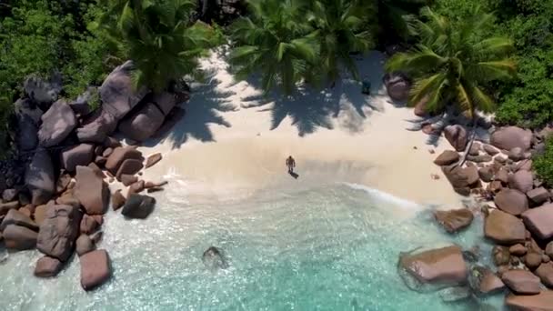 Praslin Seychelles île tropicale avec withe plages et palmiers, couple hommes et femmes d'âge moyen en vacances aux Seychelles visitant la plage tropicale de l'Anse Lazio Praslin Seychelles vue sur drone — Video