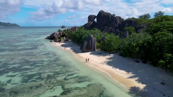 Anse Source dArgent beach, La Digue Island, Seyshelles, Drone légi kilátás a La Digue Seychelles madártávlatból, pár férfi és nő sétál a strandon napnyugtakor egy luxus nyaralás — Stock videók