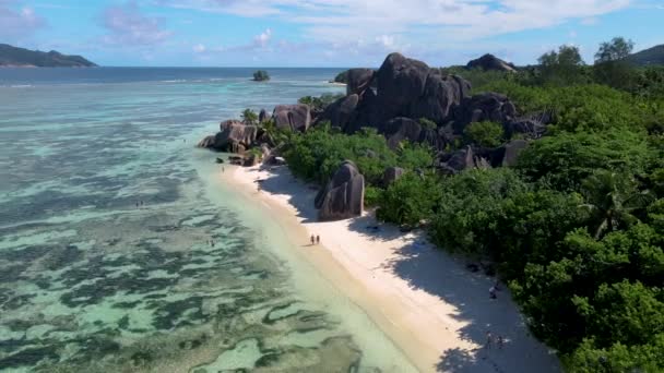 Anse Source dArgent beach, La Digue Island, Seyshelles, Drone aerial view of La Digue Seychelles bird eye view, couple men and woman walking at the beach during sunset at a luxury vacation — стокове відео