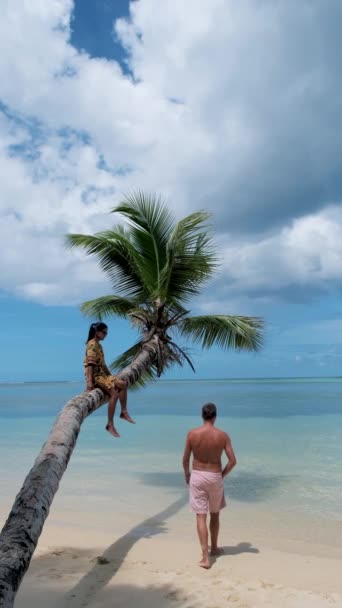 Anse Takamaka stranden Mahe Seychellerna, tropisk strand med palmer och ett blått hav, par man och kvinna på stranden — Stockvideo
