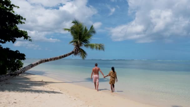 Anse Takamaka plage Mahe Seychelles, plage tropicale avec palmiers et un océan bleu, couple homme et femme sur la plage — Video