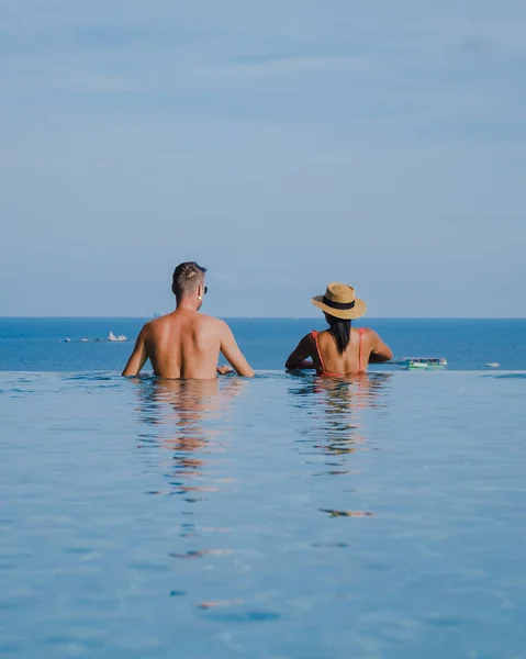 Couple man and woman on a luxury vacation enjoying the infinity pool on the rooftop, Pattaya Thailand — Foto Stock