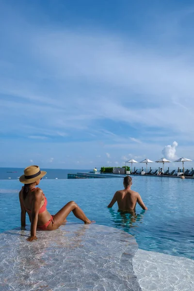 Pareja de hombres y mujeres en unas vacaciones de lujo disfrutando de la piscina infinita en la azotea, Pattaya Tailandia —  Fotos de Stock