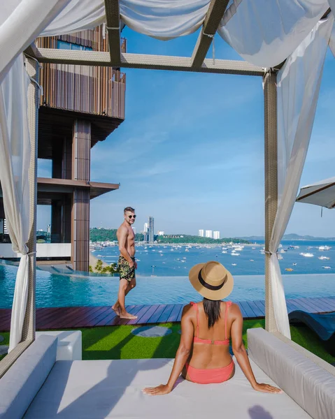 Couple man and woman on a luxury vacation enjoying the infinity pool on the rooftop, Pattaya Thailand — Stock fotografie