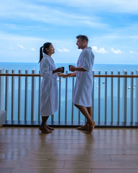 Paar mannen en vrouwen die een koffie op het balkon met uitzicht op de baai van Pattaya, Thaise meisje en Europese man op het balkon van appartement appartement appartement in Thailand — Stockfoto