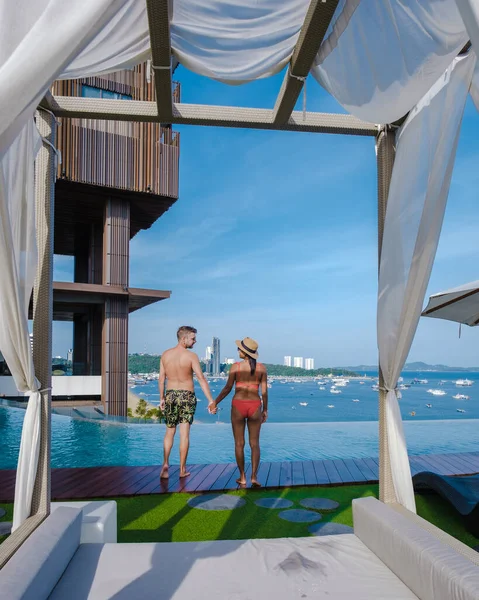 Couple man and woman on a luxury vacation enjoying the infinity pool on the rooftop, Pattaya Thailand — Stok fotoğraf