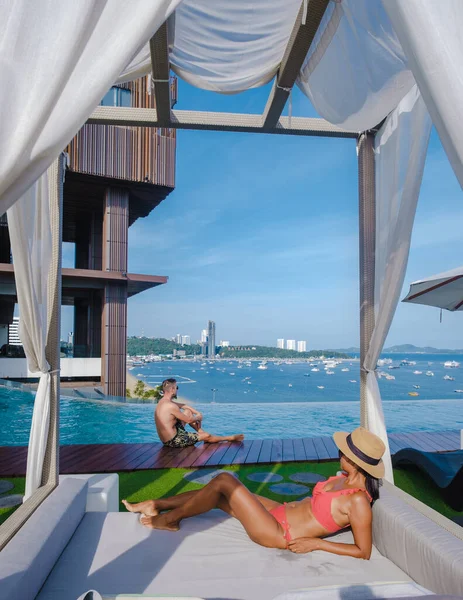 Couple man and woman on a luxury vacation enjoying the infinity pool on the rooftop, Pattaya Thailand — Stok fotoğraf
