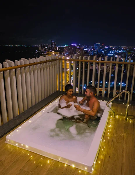 Casal homem e mulher em umas férias de luxo desfrutando da piscina infinita no telhado, Pattaya Tailândia — Fotografia de Stock
