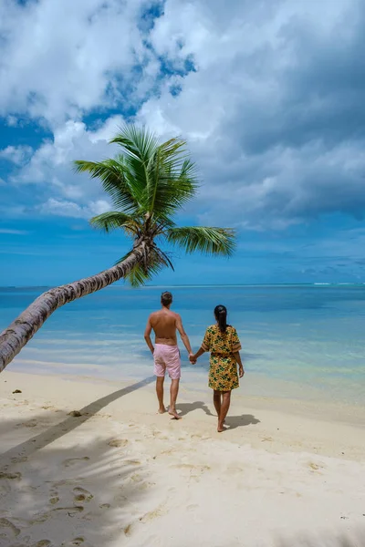 Пляж Mahe Seychelles с пальмами и голубым океаном на пляже Mahe Seychelles Anse Royale, пара мужчина и женщина на отдыхе Seychelles — стоковое фото