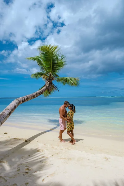 Пляж Mahe Seychelles с пальмами и голубым океаном на пляже Mahe Seychelles Anse Royale, пара мужчина и женщина на отдыхе Seychelles — стоковое фото