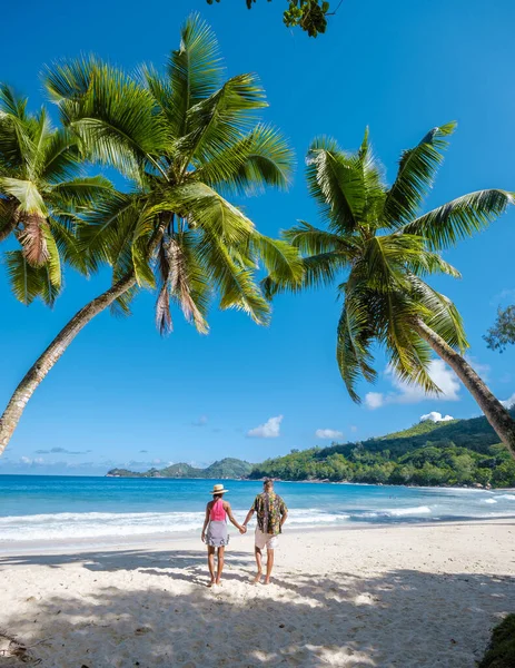 Couple man and woman on vacation Seychelles, Mahe Seychelles, tropical beach with palm trees and a blue ocean at Mahe Seychelles Anse Takamaka beach Mahe Seychelles — Stockfoto