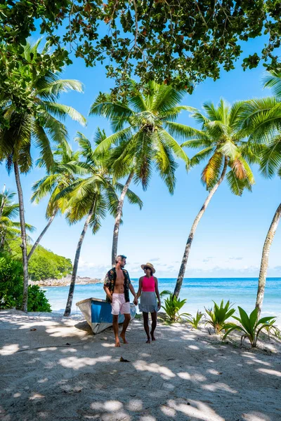 Couple man and woman on vacation Seychelles, Mahe Seychelles, tropical beach with palm trees and a blue ocean at Mahe Seychelles Anse Takamaka beach Mahe Seychelles — 스톡 사진