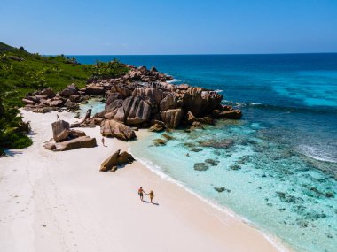 Anse Cocos La Digue Seyşeller, Seyşeller 'de lüks bir tatil sırasında tropik bir plajda yaşayan genç bir çift. Tropik sahil Anse Cocos La Digue Seyşeller