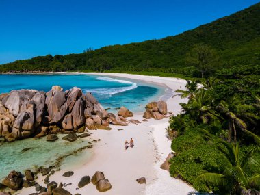 Anse Cocos La Digue Seyşeller, Seyşeller 'de lüks bir tatil sırasında tropik bir plajda yaşayan genç bir çift. Tropik sahil Anse Cocos La Digue Seyşeller