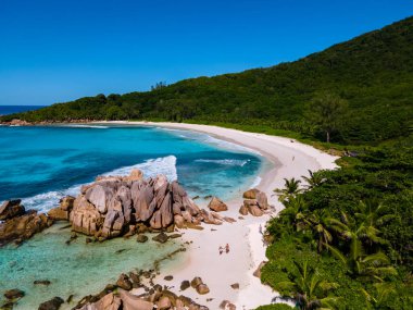 Anse Cocos La Digue Seyşeller, Seyşeller 'de lüks bir tatil sırasında tropik bir plajda yaşayan genç bir çift. Tropik sahil Anse Cocos La Digue Seyşeller