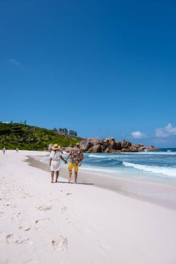 Anse Cocos La Digue Seyşeller, Seyşeller 'de lüks bir tatil sırasında tropik bir plajda yaşayan genç bir çift. Tropik sahil Anse Cocos La Digue Seyşeller