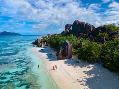 Anse Source dArgent, La Digue Seychelles, Seyşeller 'de lüks bir tatil sırasında tropik bir plajda yaşayan genç bir çift. Tropik sahil Anse Kaynak dArgent, La Digue Seyşeller