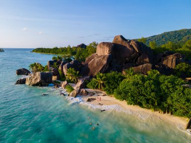 Anse Source dArgent, La Digue Seychelles, Seyşeller 'de lüks bir tatil sırasında tropik bir plajda yaşayan genç bir çift. Tropik sahil Anse Kaynak dArgent, La Digue Seyşeller