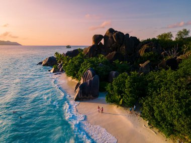 Anse Source dArgent, La Digue Seychelles, Seyşeller 'de lüks bir tatil sırasında tropik bir plajda yaşayan genç bir çift. Tropik sahil Anse Kaynak dArgent, La Digue Seyşeller
