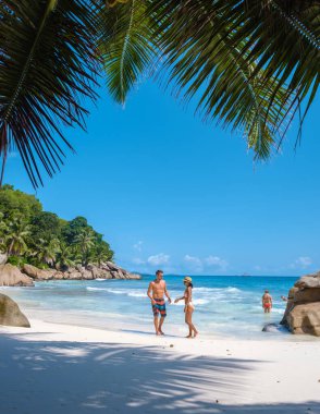 Anse Patates, La Digue Seyşeller, Seyşeller 'de lüks bir tatil sırasında tropik bir plajda yaşayan genç bir çift. Tropik sahil Anse Patates, La Digue Seyşeller