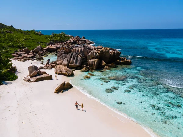 Anse Cocos La Digue Seychely, mladý pár mužů a žen na tropické pláži během luxusní dovolené na Seychelách. Tropická pláž Anse Cocos La Digue Seychely — Stock fotografie