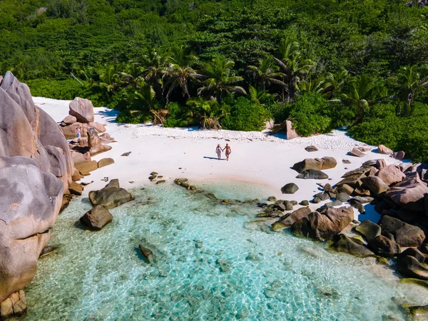 Anse Cocos La Digue Seychelles, young couple men and woman on a tropical beach during a luxury vacation in the Seychelles. Tropical beach Anse Cocos La Digue Seychelles — Stockfoto