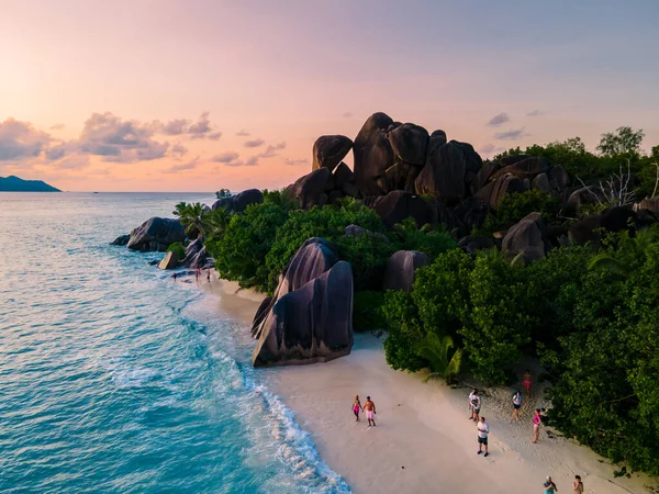 Anse Source dArgent, La Digue Seychelles, Seyşeller 'de lüks bir tatil sırasında tropik bir plajda yaşayan genç bir çift. Tropik sahil Anse Kaynak dArgent, La Digue Seyşeller