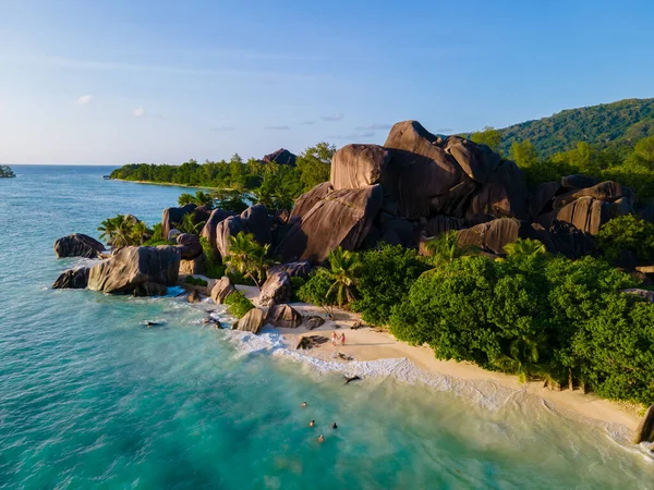 Anse Source dArgent, La Digue Seychelles, Seyşeller 'de lüks bir tatil sırasında tropik bir plajda yaşayan genç bir çift. Tropik sahil Anse Kaynak dArgent, La Digue Seyşeller