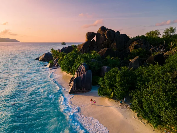 Anse Source dArgent, La Digue Seychelles, Seyşeller 'de lüks bir tatil sırasında tropik bir plajda yaşayan genç bir çift. Tropik sahil Anse Kaynak dArgent, La Digue Seyşeller