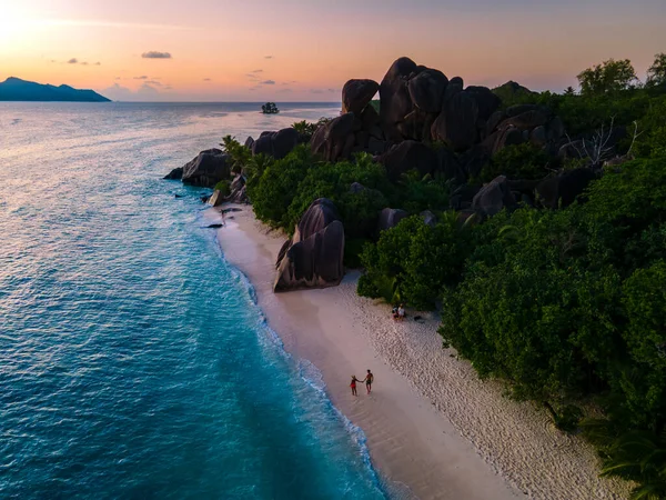 Anse Source dArgent, La Digue Seychelles, Seyşeller 'de lüks bir tatil sırasında tropik bir plajda yaşayan genç bir çift. Tropik sahil Anse Kaynak dArgent, La Digue Seyşeller