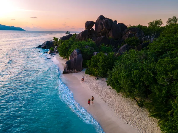 Anse Source dArgent, La Digue Seychelles, Seyşeller 'de lüks bir tatil sırasında tropik bir plajda yaşayan genç bir çift. Tropik sahil Anse Kaynak dArgent, La Digue Seyşeller