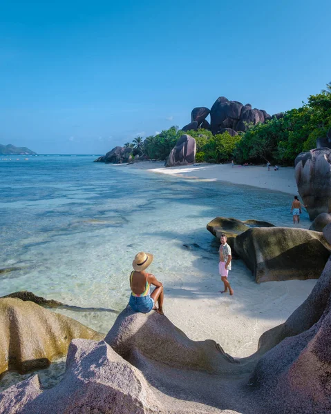 Anse Source dArgent, La Digue Seychelles, Seyşeller 'de lüks bir tatil sırasında tropik bir plajda yaşayan genç bir çift. Tropik sahil Anse Kaynak dArgent, La Digue Seyşeller